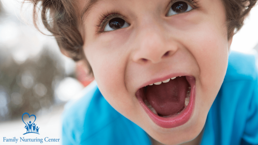 An exuberant young boy smiles on the cover of Family Nurturing Center's annual report. Beneath his photo is the nonprofit's vision "safe children, thriving families, nurturing communities."